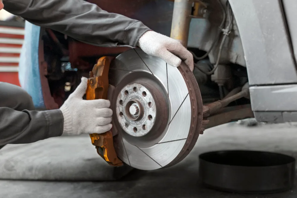 Mechanic replacing brake pads on car in Perth